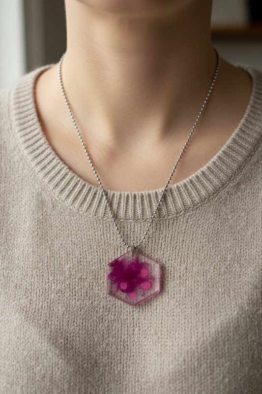 Magenta and purple alcohol ink hexagon resin pendant necklace on a silver ball chain being worn