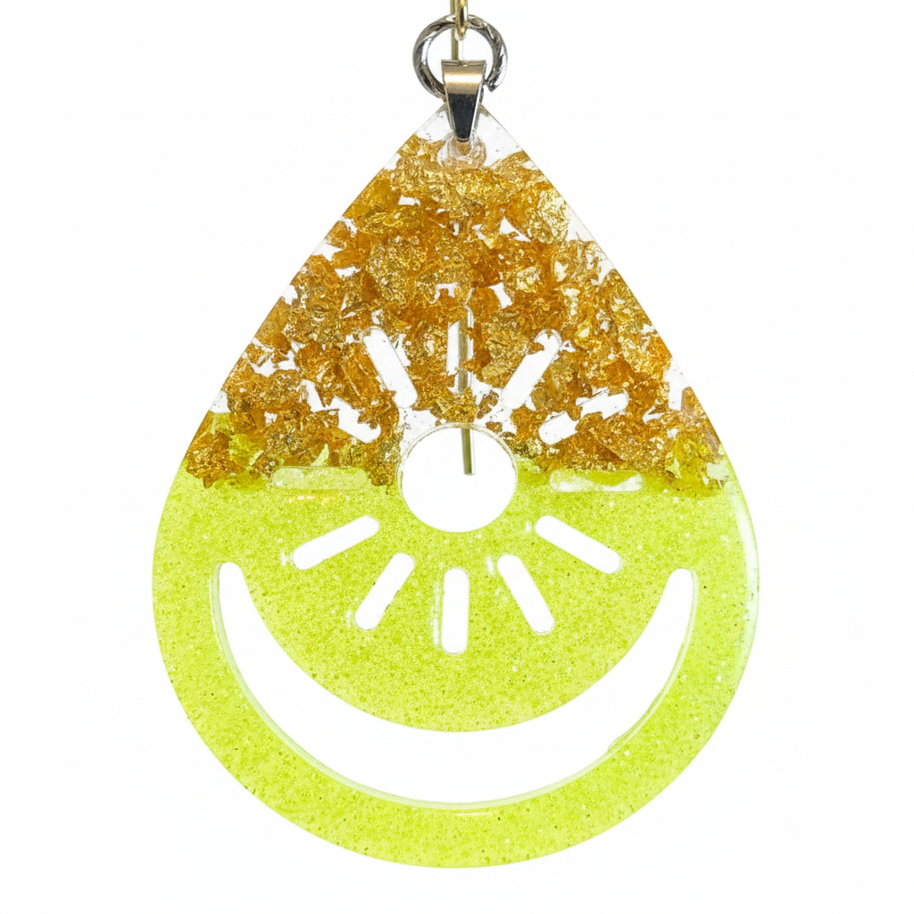 Macro close-up of handmade neon yellow resin teardrop earring showing intricate open-work citrus wheel cut-out with segmented seed details and reflective gold foil flakes at top in bright natural light