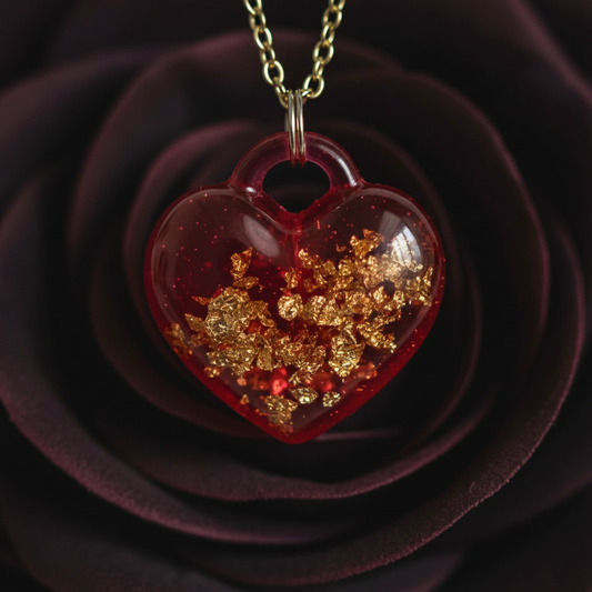 Close-up macro photo of crimson heart resin pendant showing rich red depth and gold foil flake detail