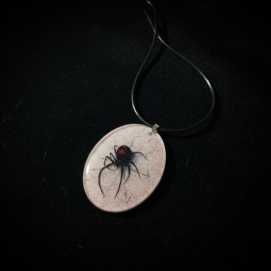 Black widow spider oval pendant necklace shown flat on black velvet