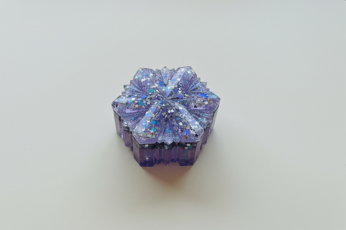 Purple and silver Snow Queen resin jewelry box centered on a light neutral surface in a flat-lay product photo